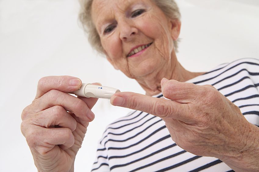 Ältere Frau bestimmt Blutzuckerwert bei Diabetes. 