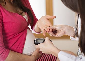 Ärztin testet  Blutzucker bei einer Schwangeren, um  Schwangerschaftsdiabetes auszuschließen.