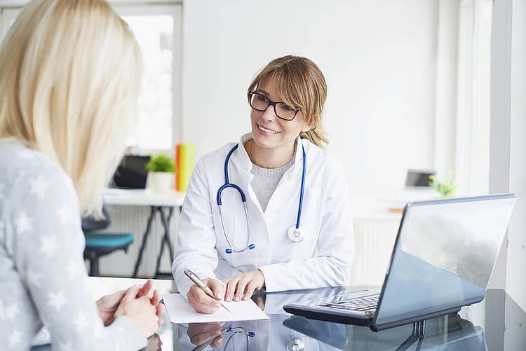 Ärztin und Patientin beraten Ergebnisse eines Selbsttests