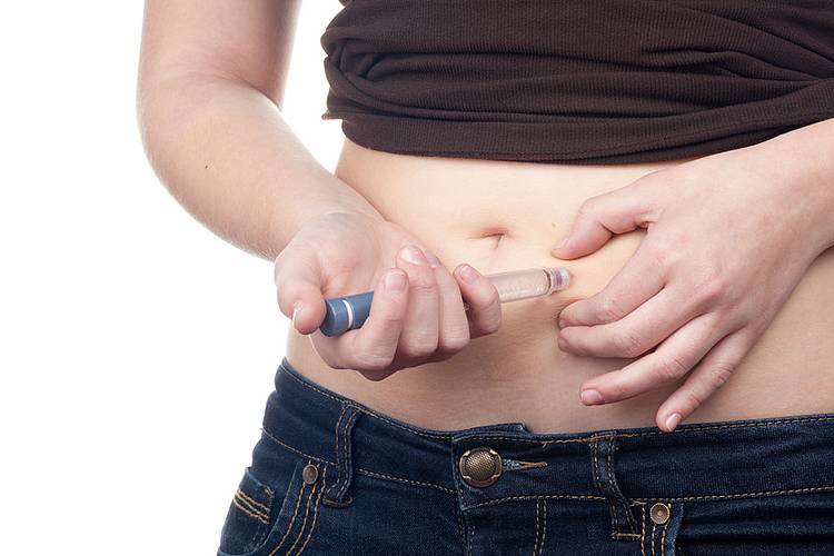 Junge Frau spritzt sich Insulin in die Bauchdecke