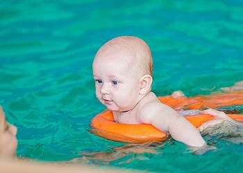 Baby mit Mutter beim Babyschwimmen im Schwimmbad