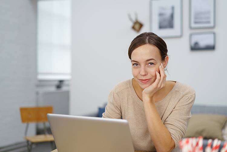 Junge Frau recherchiert am Laptop Informationen