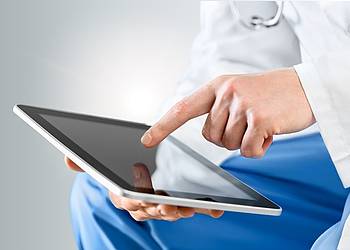 Arzt sucht mit seinem Tablet Informationen zu Symptomen, Diagnose und Behandlung der Zikavirus-Infektion.