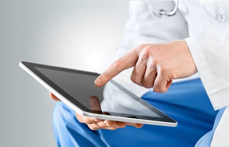 Arzt sucht mit seinem Tablet Informationen zu Symptomen, Diagnose und Behandlung der Zikavirus-Infektion.
