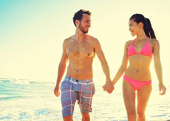 Schlankes junges Paar am Strand