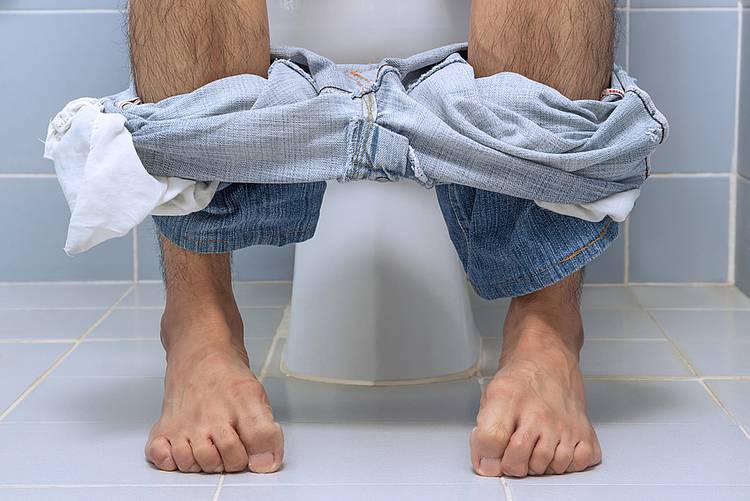 Männerbeine vor WC-Schüsseln