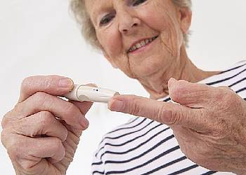 Ältere Frau mit Diabetes bestimmt ihren Blutzuckerwert zur Vorbeugung eines Schlaganfalls.