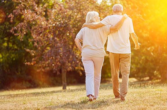 Älteres Paar geht im Septembersonnenschein spazieren.