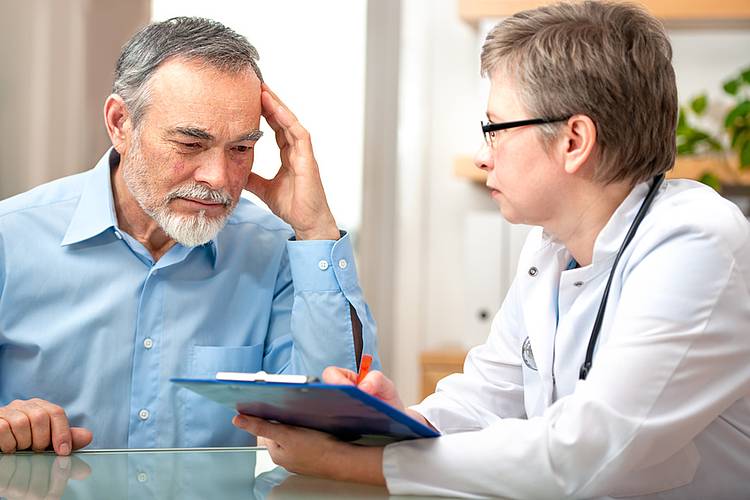 Ärztin berät einen älteren Mann zu personalisierter Medizin bei Darmkrebs