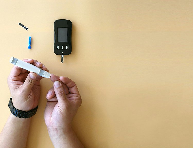 Das Foto zeigt zwei Hände, die einen Diabetes-Pen bedienen.