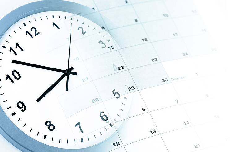 Uhr liegt neben Terminkalender