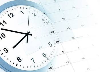 Uhr liegt neben Terminkalender