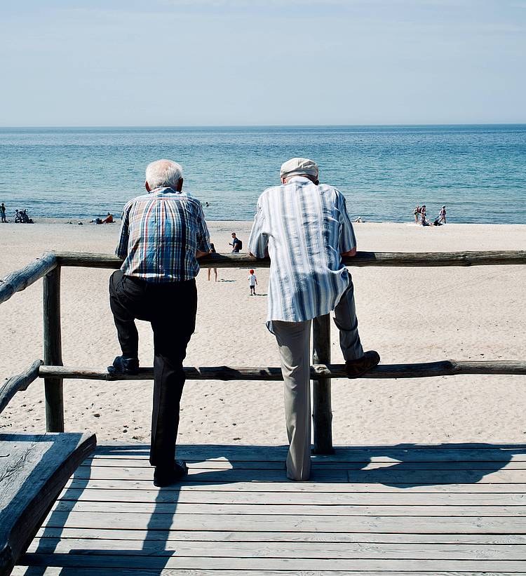 Zwei ältere Männer blicken auf den Strand