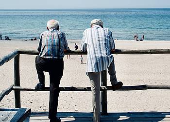 Zwei ältere Männer blicken auf den Strand
