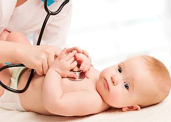 Kinderärztin untersucht Baby mit Stethoskop. 