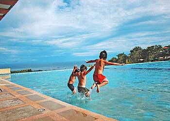 Kinder springen ins Wasser im Freibad