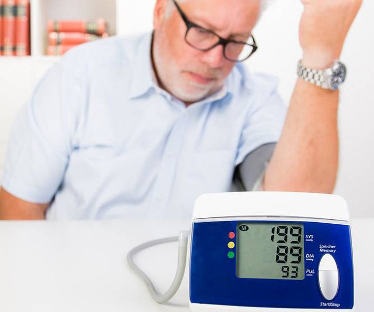 Mann mit Diabetes misst Blutdruck, um Bluthochdruck rechtzeitig zu erkennen. 