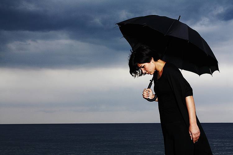 Depressive Frau mit Regenschirm