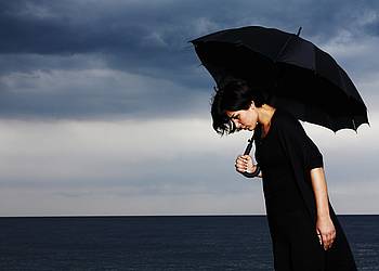 Depressive Frau mit Regenschirm