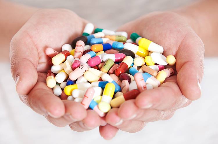 Zwei Hände voller Antibiotika-Tabletten.