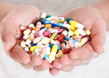 Zwei Hände voller Antibiotika-Tabletten.
