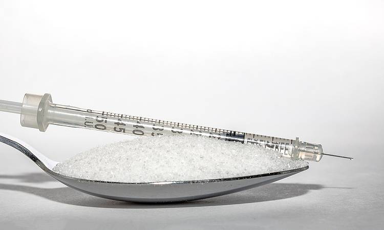 Insulinspritze mit einem Löffel Zucker