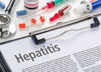 Klemmbrett mit Fachartikel über Hepatitis und Hepatitis-Medikamente