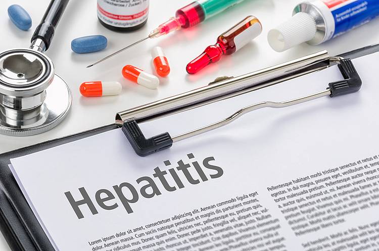 Klemmbrett mit Fachartikel über Hepatitis und Hepatitis-Medikamente