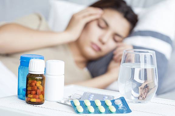 Frau mit Erkältung nimmt Antibiotika ein