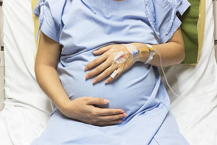 Schwangere im Krankenhausbett mit Infusion