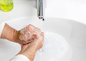 Mann wäscht sich gründlich die Hände mit Seife