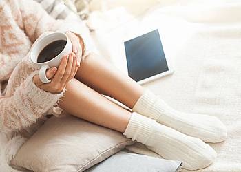 Frau mit dickem Pullover und Kaffeetasse 