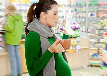Schwangere Frau mit Grippe in der Apotheke