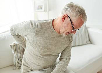 Senior hält sich den schmerzenden Rücken
